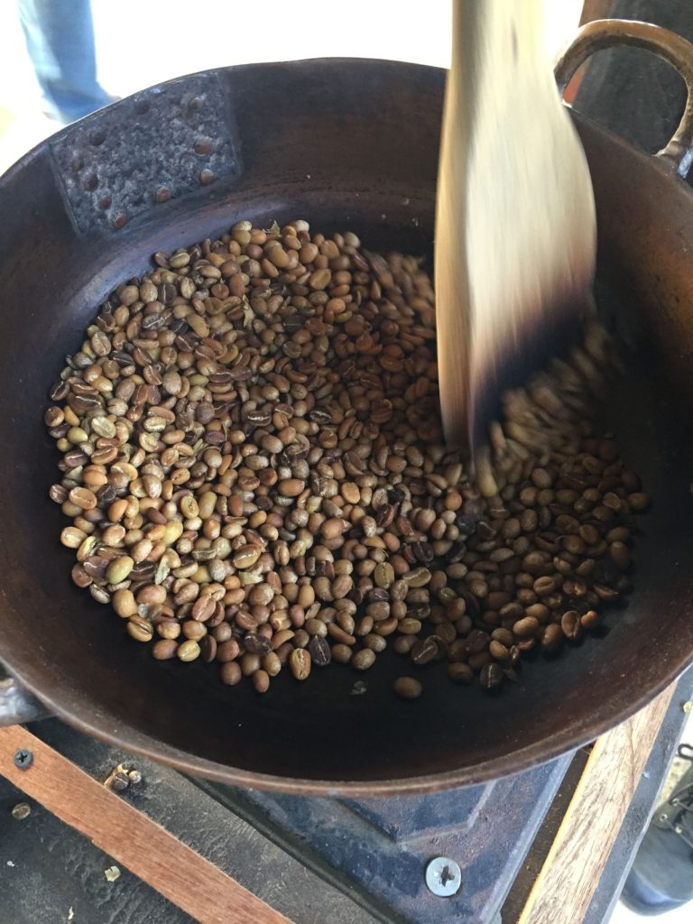 Coffee beans roasting in copper pot